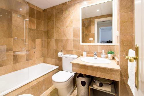 a bathroom with a toilet and a sink and a tub at OleHolidays Gala junto a Puente Romano in Marbella