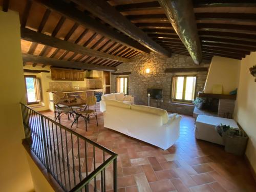 a living room with a white couch and a kitchen at Agriturismo Popolano Di Sotto in Marradi
