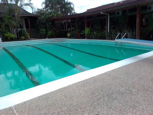 a swimming pool in front of a house at Hotel Santa Helena in Leticia