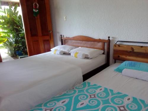two beds sitting next to each other in a room at Hotel Santa Helena in Leticia