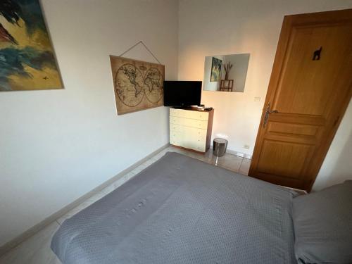 1 dormitorio con 1 cama y puerta de madera en Chambre privé avec Sdb privative, en Le Cannet