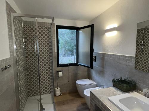 a bathroom with a shower and a toilet and a sink at Casa Chia a 5 minuti dal mare - Su Giudeu Tuerredda in Chia