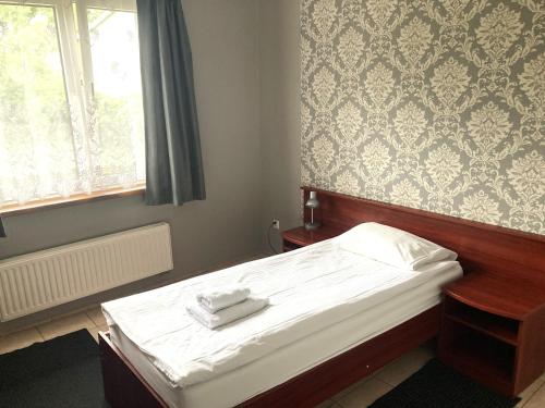 a small bedroom with a bed and a window at Hotel Ava in Gliwice
