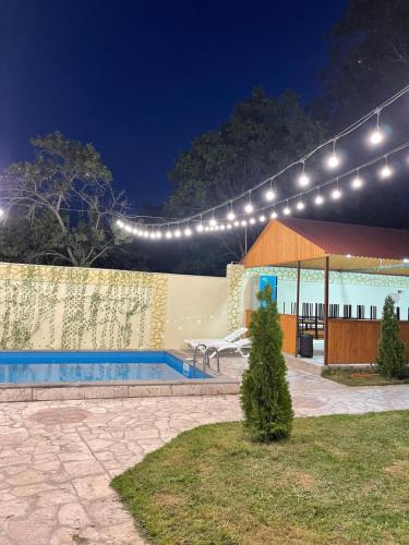 basen w nocy z oświetleniem nad nim w obiekcie Hasy tun guest house in GARNI w Garni