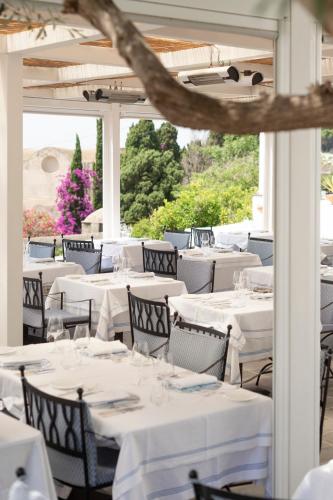 a restaurant with white tables and chairs at Hotel Canasta in Capri