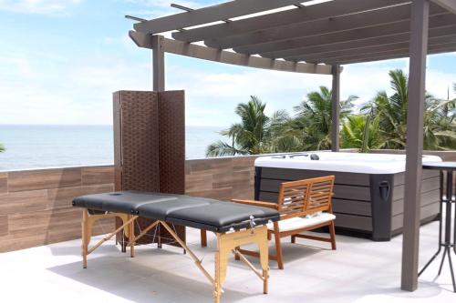 a pergola and a table and chairs on a patio at Serenity Residences & Spa - Kokrobite Beach in Kokrobite