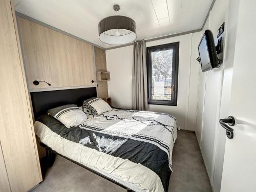 een kleine slaapkamer met een bed en een raam bij Chalet Jullouville, 4 pièces, 6 personnes - FR-1-361-477 in Jullouville-les-Pins