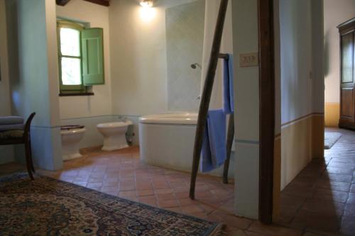 ein Badezimmer mit 2 WCs und einer Badewanne in der Unterkunft L'Ariete in Montone