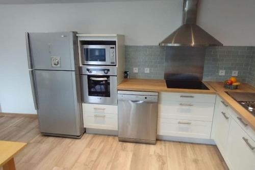 Il comprend une cuisine avec des appareils en acier inoxydable et du parquet. dans l'établissement Charmante maison de campagne, avec jardin, vue rivière, 15 min Cabourg, à Basseneville