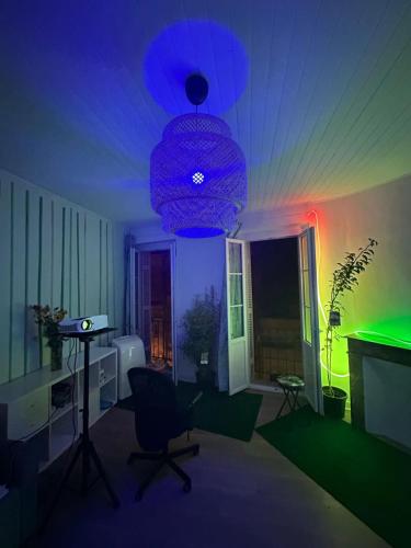 Cette chambre comprend un bureau et une lumière verte. dans l'établissement Un jacuzzi a Bordeaux, à Bordeaux