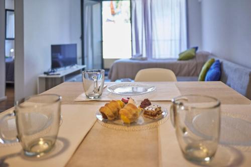 un tavolo con un piatto di dolci e bicchieri di Palacios Bari Alojamientos a San Carlos de Bariloche