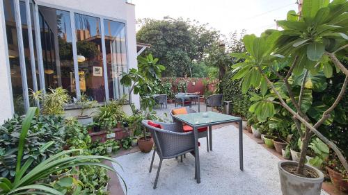 eine Terrasse mit einem Tisch, Stühlen und Pflanzen in der Unterkunft Ekaa Villa near Taj Mahal in Agra