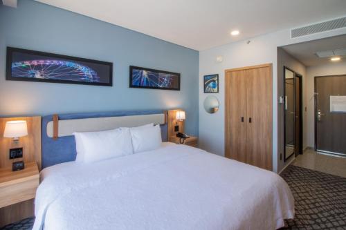 a hotel room with a large white bed and blue walls at Hampton by Hilton Aguascalientes Downtown in Aguascalientes