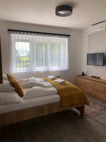 1 dormitorio con cama grande y ventana grande en Martin Apartmanok, en Bük