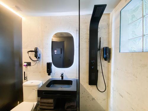 Modern Black Studio Penthouse En Valle De Incles - Parking Gratis في كانيلو: حمام مع حوض ومرآة
