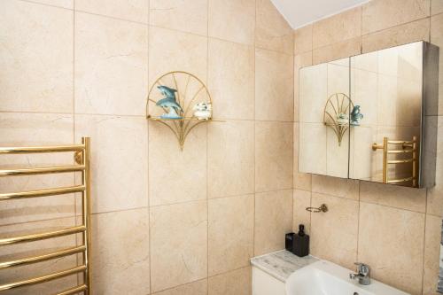 a bathroom with a sink and a mirror at Floral, 5 Bed House in London with Garden, Parking in Dagenham