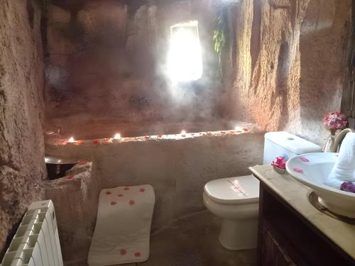 baño con aseo y lavabo con velas en La Cova de Can Pavet en Pontons