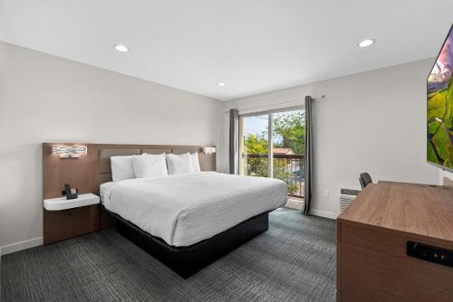 a hotel room with a bed and a window at Cedar Street Hotel & Suites in Sandpoint