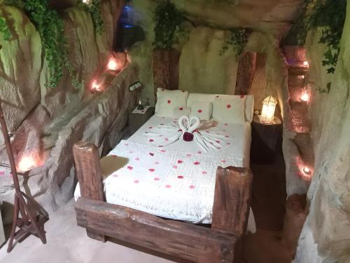 a bedroom with a bed in a cave with lights at La Cova de Can Pavet in Pontons