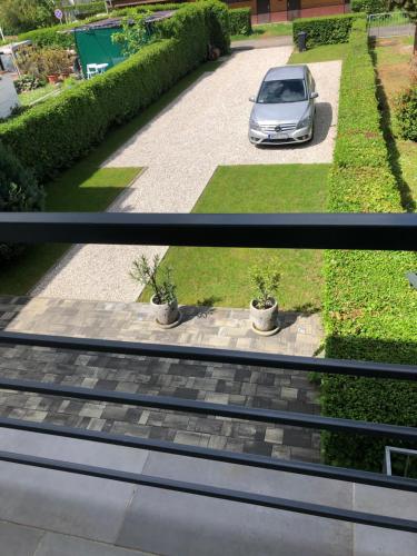 two pictures of a car parked in a driveway at Martin Apartmanok in Bük