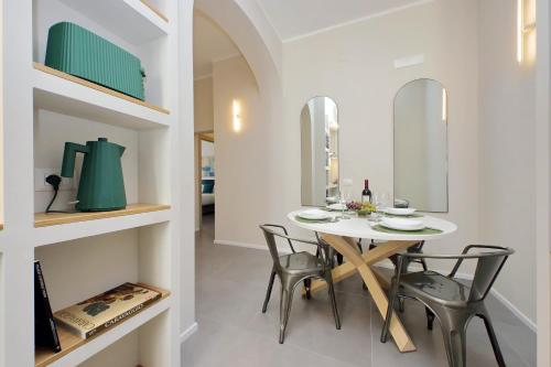 a dining room with a white table and chairs at Youcomehere - Montebello in Rome