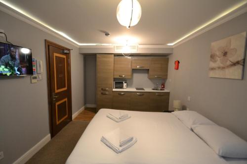 a small room with a bed and a kitchen at Hyde Park Suites in London