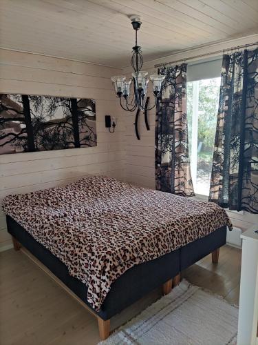 a bedroom with a bed in a room with a chandelier at Kaukuanjärven Kimallus in Kuloharju