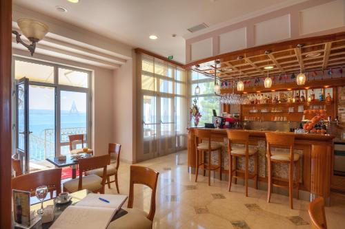 a restaurant with a bar with a view of the ocean at Hotel Sunceva Postelja Brela in Brela