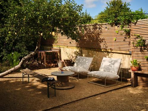 a patio with two chairs and a table and a fireplace at Bay House Studio in Bath