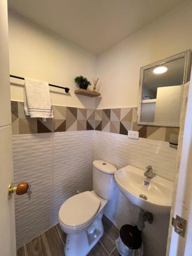 a bathroom with a toilet and a sink at CASA HOTEL FLOR DEL VALLE in Cali