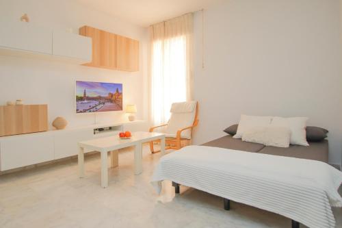 a white bedroom with a bed and a table at Modern APT next to Old Town - 10m walk Isla Mágica in Seville