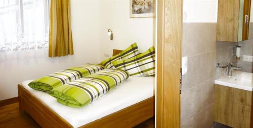 Bett mit gelben und schwarzen Kissen in einem Zimmer in der Unterkunft Ferienwohnung Natural B in Gerlosberg