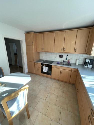 a kitchen with wooden cabinets and a tile floor at Ferienwohnung Blessinger in Coburg