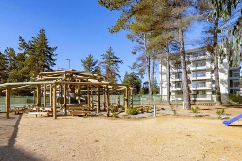 um parque infantil num parque com bancos e um edifício em Depto hermoso El Tabo em El Tabo