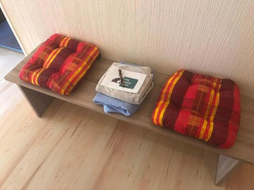 eine Holzbank mit zwei Kissen und einer Decke in der Unterkunft Ferienhaus Elbe-Ilenpool in Bleckede