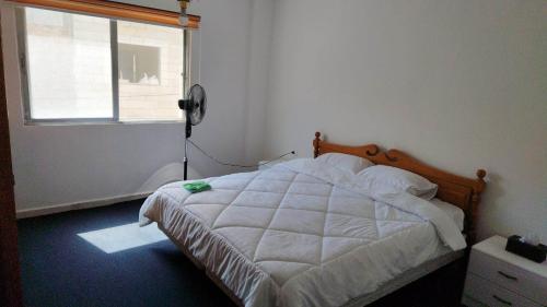 a bedroom with a bed and a window at City Center Hostel in Jerash