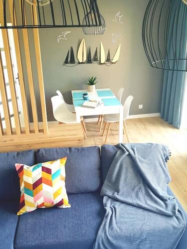 uma sala de estar com um sofá azul e uma mesa em Spokojna Marina em Puck
