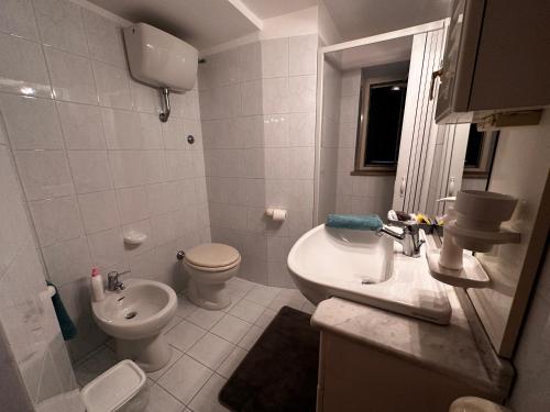 a white bathroom with a toilet and a sink at LA CASA IN COLLINA in Veroli