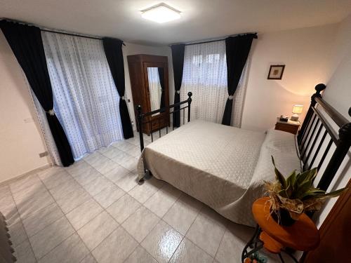 ein Schlafzimmer mit einem Bett und zwei Fenstern in der Unterkunft LA CASA IN COLLINA in Veroli