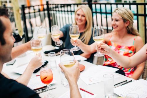 a group of people sitting around a table drinking wine at The Myriad Hotel Louisville, Tapestry Collection by Hilton in Louisville