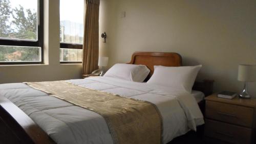 En eller flere senger på et rom på Crown Suites Ltd Mbale