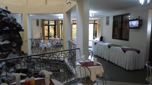 a room with a balcony with tables and chairs at Crown Suites Ltd Mbale in Mbale