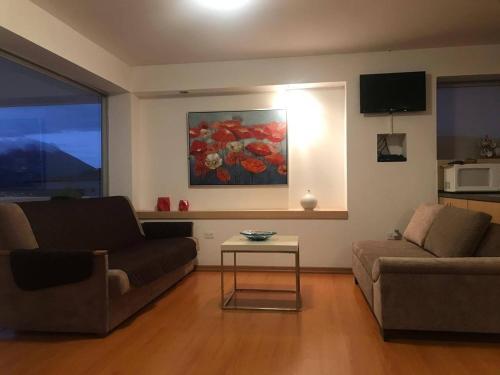 a living room with a couch and a table at Urbanización El Condado. in Quito