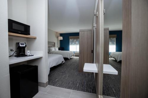 a hotel room with two beds and a television at Holiday Inn Express & Suites Tampa Stadium - Airport Area by IHG in Tampa