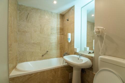 uma casa de banho com uma banheira, um lavatório e um WC. em HOTEL VITAL em Baile Felix