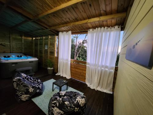 Zimmer mit 2 Stühlen und einer Badewanne in einer Hütte in der Unterkunft Au Doux Refuge 2 in Le Lambert