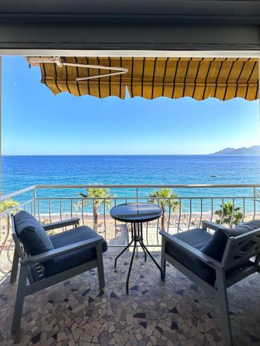 un patio avec des chaises et une table et l'océan dans l'établissement Plage du midi- Vue sur mer Standing Presta, à Cannes