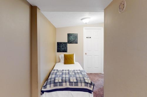 a small bedroom with a bed with a yellow pillow at Scenic View Lodge - Entire Property in Bloomington