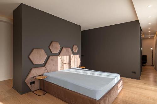a bedroom with a large bed with a black wall at Sauna&Jacuzzi Apartment in Cluj-Napoca