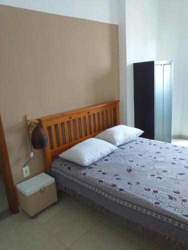 a bedroom with a bed and a lamp in it at Apartamento Canto do Forte in Praia Grande